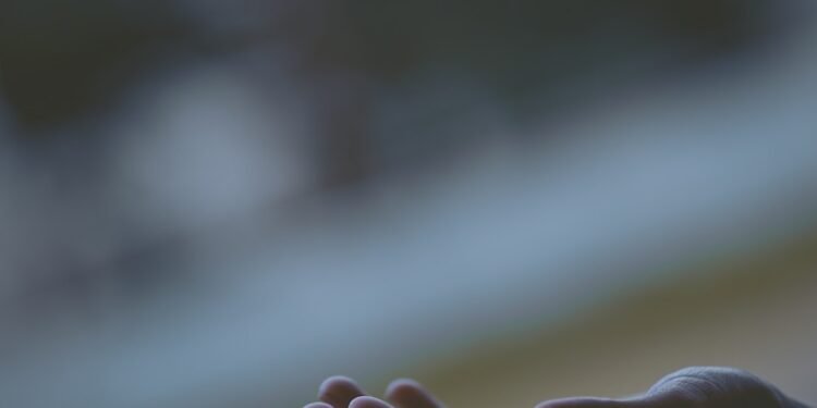 shallow focus photography of white feather dropping in person's hand